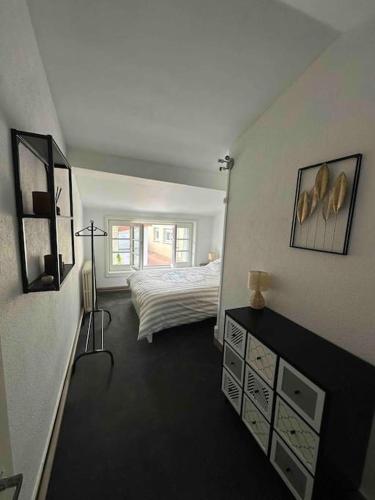 Habitación blanca con cama y dormitorio con ventana en Appartement avec grande terrasse, en Saint-Alban-les-Eaux