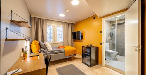 a small room with a bed and a bathroom at Hotelli Visiitti in Ylivieska