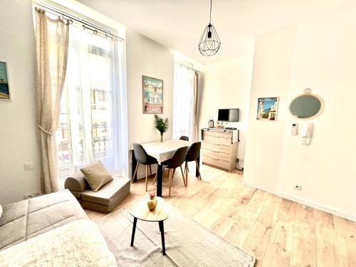 ein Wohnzimmer mit einem Tisch und einem Sofa in der Unterkunft Studio center 104 in Cannes