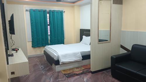 een slaapkamer met een bed, een stoel en een spiegel bij Raj Darbar Hotel in Goddā