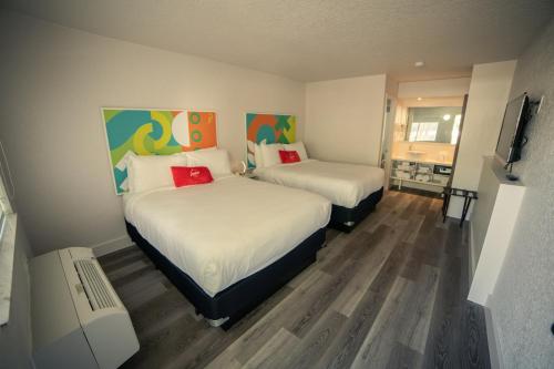 um quarto com duas camas e uma televisão em Developer Inn Express Fundamental, a Travelodge by Wyndham em Kissimmee