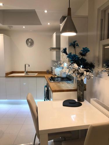 a kitchen with a table with a vase of flowers on it at Modern 1 bed Blackheath Apartment in Blackheath