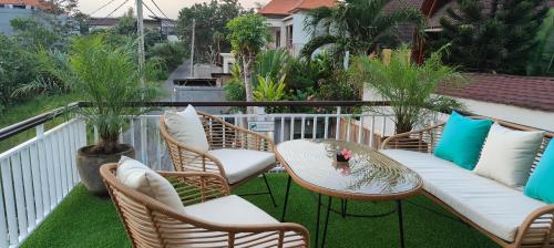a patio with chairs and a table and a table and chairs at The Palms Canggu in Canggu