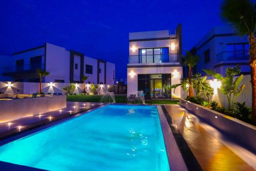 une villa avec une piscine la nuit dans l'établissement The Wave Villa - Fujairah, à Fujaïrah