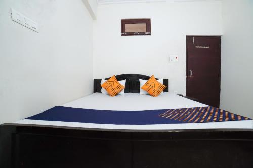 Una cama con almohadas de color naranja y azul. en OYO Star Guest House, en Bara Khera