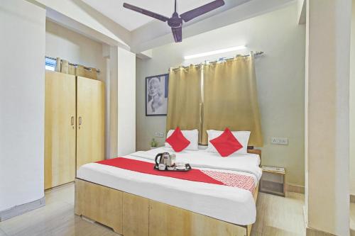 - une chambre avec un grand lit et des oreillers rouges dans l'établissement OYO The Jumbo Stay, à Ālīpur