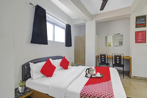- une chambre avec un lit et des oreillers rouges dans l'établissement OYO The Jumbo Stay, à Ālīpur