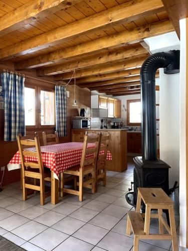 - une cuisine avec une table et un poêle à bois dans l'établissement Chalet le Génépi 4-6 pers, à Champagny-en-Vanoise