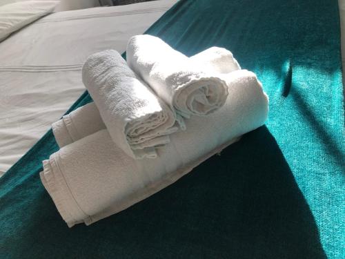 a stack of towels sitting on top of a bed at Modern 1 bed Blackheath Apartment in Blackheath