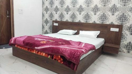 1 dormitorio con 1 cama con manta morada en OYO Hotel kadamb, en Palwal