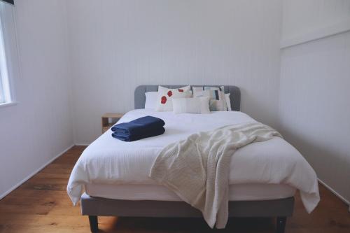 a bedroom with a large bed with white sheets at UrbanNook - Heart of the city in Brisbane