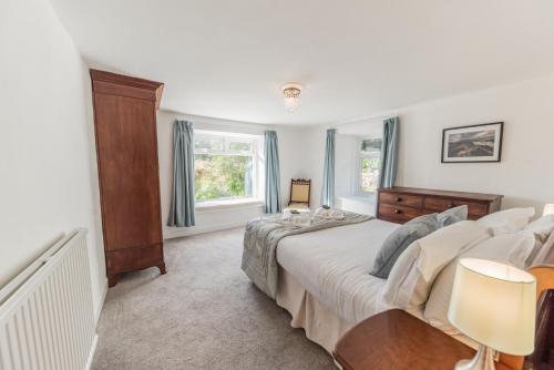 a bedroom with a large bed and a window at Lakeland farmhouse with an acre of gardens, games room and free parking in Rusland