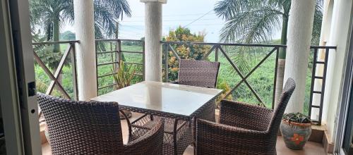 a table and chairs on a balcony with a view at Peninsula drive lake side apartments in Kampala