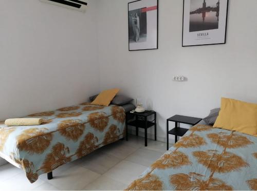 a bedroom with a bed and a bed and a table at Santillana terrazas in Seville