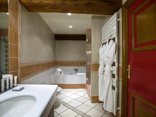 a bathroom with a tub and a toilet and a sink at Villa Florentine in Lyon