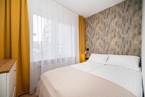 a bedroom with a white bed and a window at Apartment near Buivydiškės lakes in Vilnius