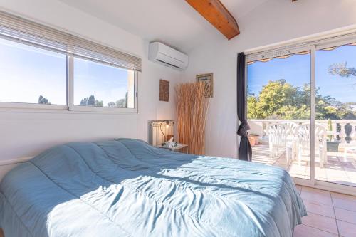 een slaapkamer met een bed en een groot raam bij Villa en Bord de Mer in Saint-Raphaël