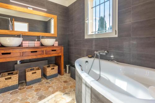 een badkamer met een bad, een wastafel en een spiegel bij Villa en Bord de Mer in Saint-Raphaël