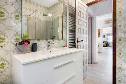 ein Badezimmer mit einem weißen Waschbecken und einem Spiegel in der Unterkunft Guillard in Pedreguer