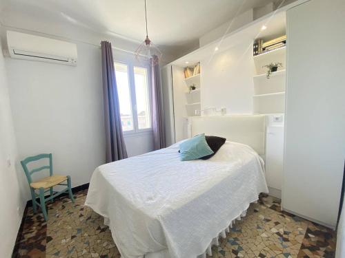 une chambre avec un lit, une chaise et une fenêtre dans l'établissement Appartement T2 à La Ciotat - Clim, WiFi, Parking - FR-1-770-25, à La Ciotat