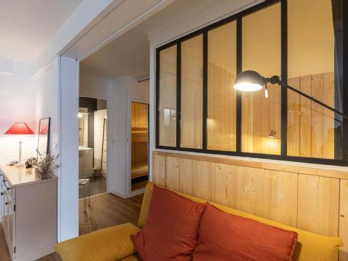 un salon avec un canapé et une grande fenêtre dans l'établissement Charmant T2 avec cuisine neuve et cave au centre de Cauterets - FR-1-401-278, à Cauterets