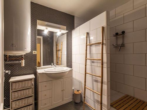 een badkamer met een wastafel en een spiegel bij Appartement Cauterets, 2 pièces, 4 personnes - FR-1-401-278 in Cauterets