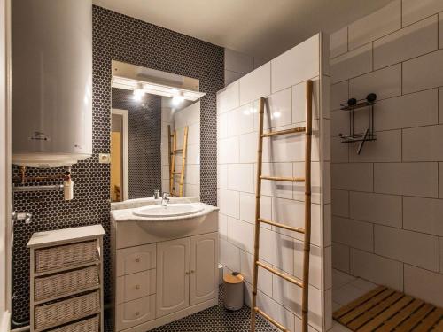 une salle de bain avec un lavabo et un miroir dans l'établissement Charmant T2 avec cuisine neuve et cave au centre de Cauterets - FR-1-401-278, à Cauterets