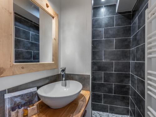 une salle de bain avec un lavabo et un miroir dans l'établissement Appartement cosy aux pieds des pistes avec services inclus - FR-1-640-57, à Val Thorens