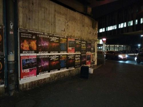 un mur avec des affiches sur le côté d'un bâtiment dans l'établissement Test Tet Qa Kari, à Munich