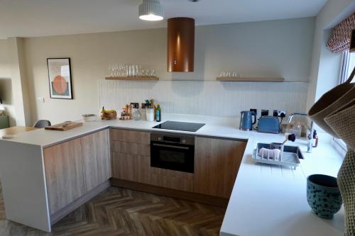 a kitchen with white counters and wooden cabinets at Oakview in Colchester