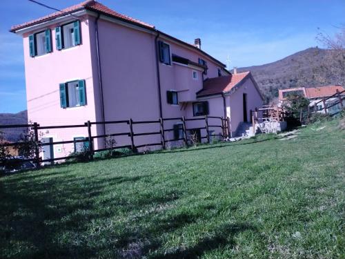 a house on a hill with a green yard at LA TANA DELLA VOLPETTA - Bed & Breakfast in Stella