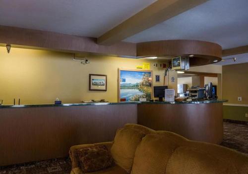 una sala de espera con sofá y bar en Norwood Inn Minneapolis Roseville en Roseville