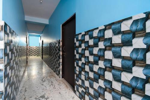 a hallway with blue walls and a door with a mosaic wall at OYO Maa Home Stays 5 in Bhubaneshwar
