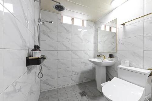 a white bathroom with a toilet and a sink at Even Hotel in Gunsan-si
