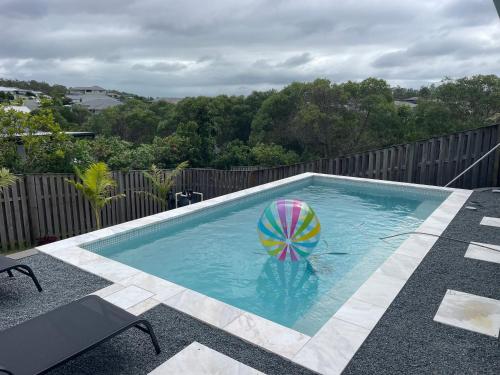 een zwembad met een strandbal in het water bij Upper Coomera Castle 1 in Gold Coast