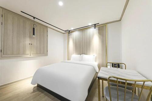 - une chambre avec un grand lit blanc et une armoire dans l'établissement Even Hotel, à Gunsan