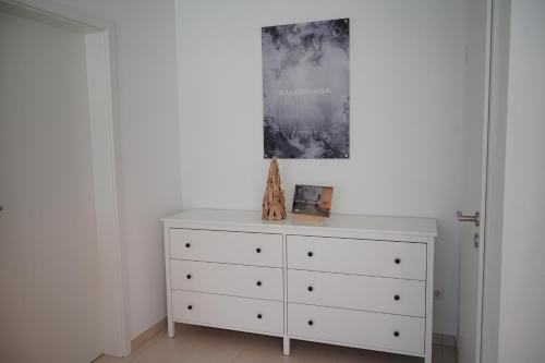a white dresser with a picture on top of it at PureNature Appartement in Obersontheim