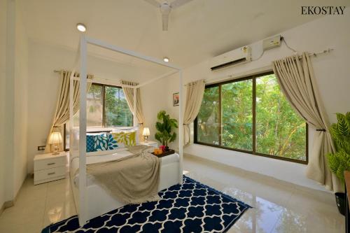 a bedroom with a bed and a large window at EKOSTAY - Water Lagoon Villa in Lonavala