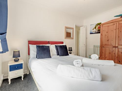 una camera da letto con un grande letto bianco con testiera rossa di 2 Bed in Brixham BX079 a Brixham
