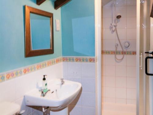 a bathroom with a sink and a shower with a mirror at 2 Bed in Aylsham KT080 in Aylsham
