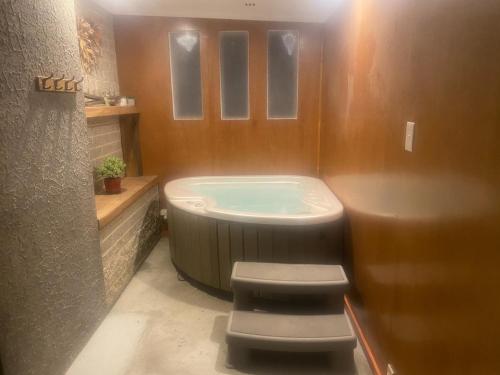 a bathroom with a tub and two stools in it at Bluegum Cottage 