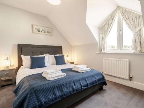 a bedroom with a bed with blue sheets and a window at 2 Bed in Beadnell CN005 in Beadnell