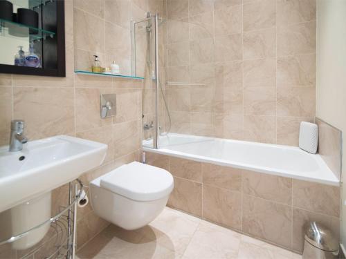 a bathroom with a toilet and a tub and a sink at 2 Bed in Ripon HH082 in Ripon