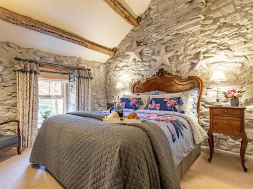 a bedroom with a stone wall with a bed at 1 Bed in Bouth LCC40 in Bouth