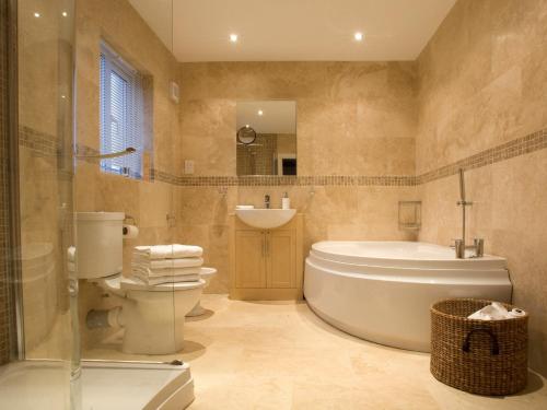 a bathroom with a tub and a toilet and a sink at 2 Bed in Cartmel LCC47 in Cartmel