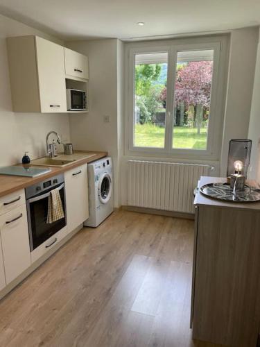 une cuisine avec un évier et une cuisinière four supérieur dans l'établissement Quartier calme : T2 plain pied avec son jardin, à Argelès-Gazost