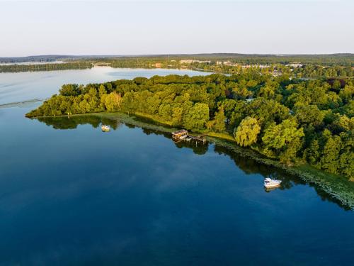 an island in a lake with two boats in it at INSELHOTEL Potsdam in Potsdam