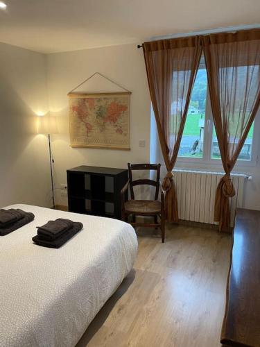 une chambre avec un lit, une chaise et une fenêtre dans l'établissement Quartier calme : T2 plain pied avec son jardin, à Argelès-Gazost