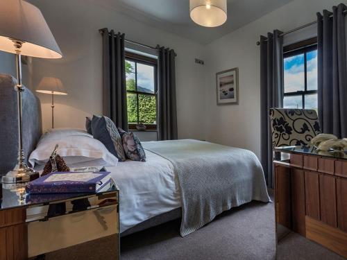 a bedroom with a bed and a desk and windows at 1 Bed in Coniston LCC50 in Coniston