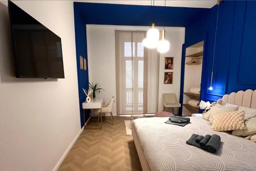 sypialnia z niebieskimi ścianami i łóżkiem z butami w obiekcie Appartamento Belle Époque nel cuore di Torino w Turynie